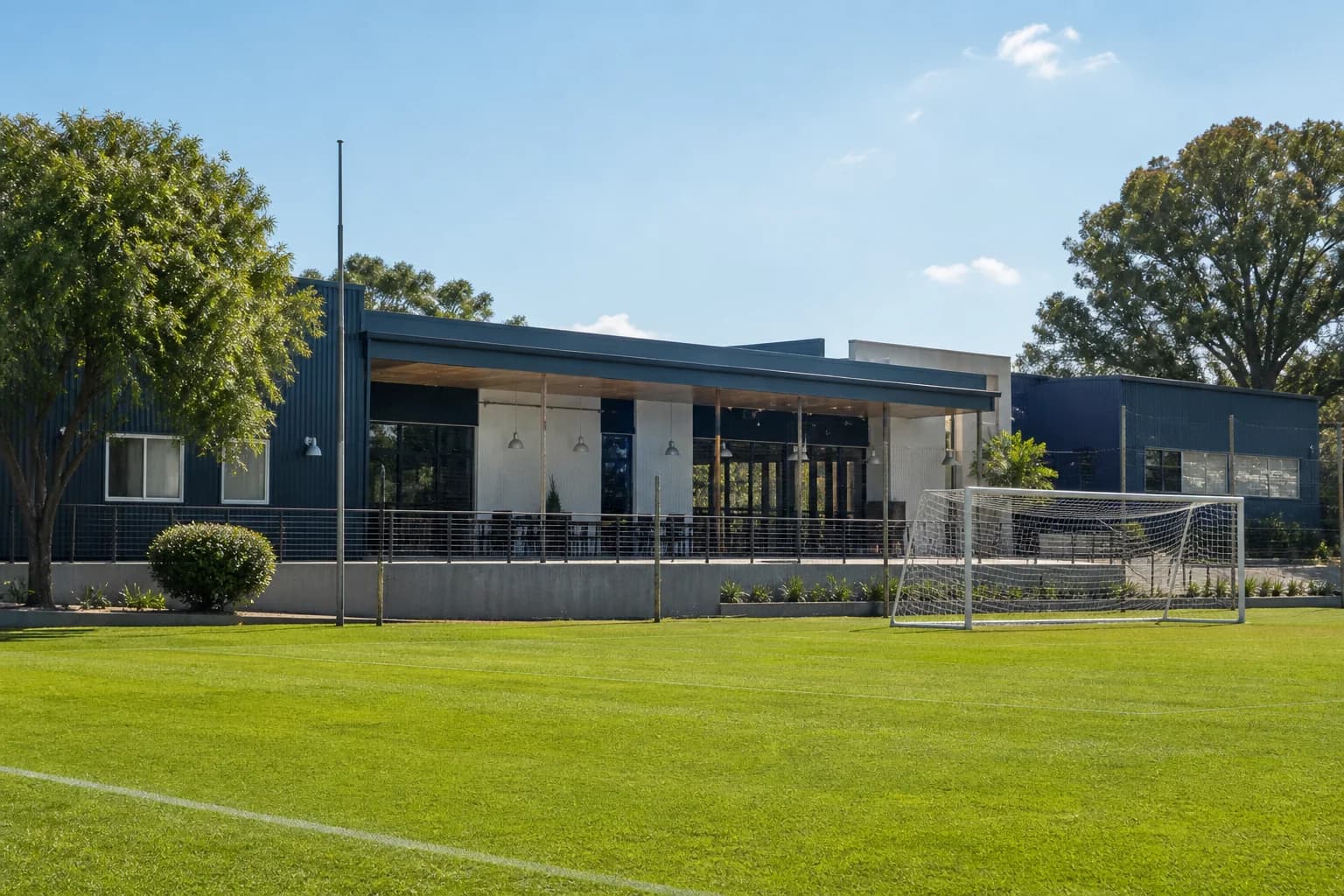 Club e institución con edificio moderno y cancha de fútbol